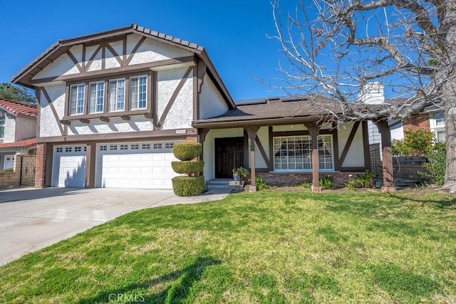 english style home featuring an attached garage, a front yard, concrete driveway, and stucco siding