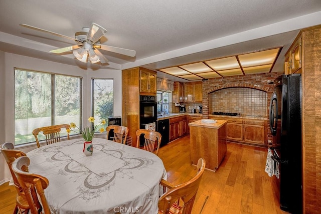 dining room with ceiling fan, light wood-style flooring, and a healthy amount of sunlight