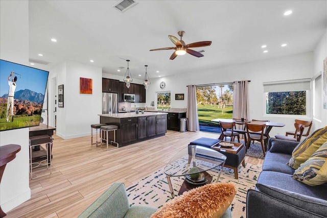 living room with ceiling fan and light wood-type flooring