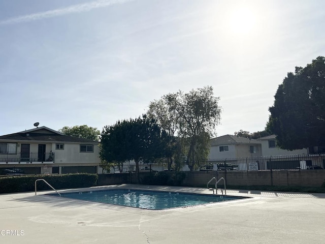 view of swimming pool with fence and a patio