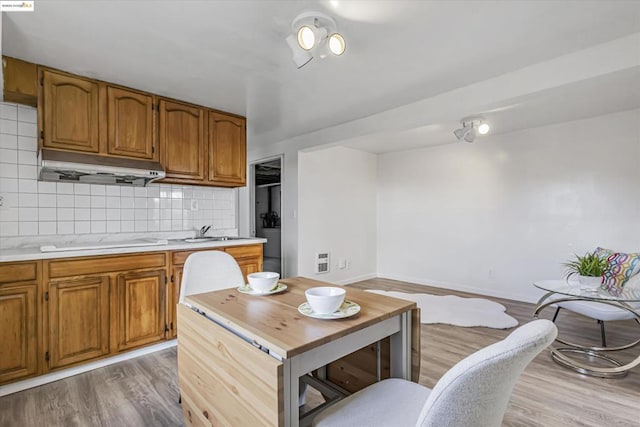 kitchen featuring electric cooktop, sink, backsplash, and light hardwood / wood-style floors