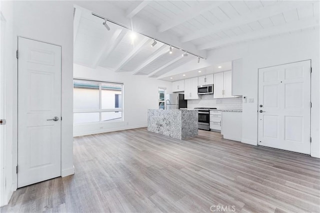 217 10th St, Seal Beach, CA 90740 - kitchen featuring track lighting, stainless steel appliances, white cabinetry, light wood-style floors, and backsplash