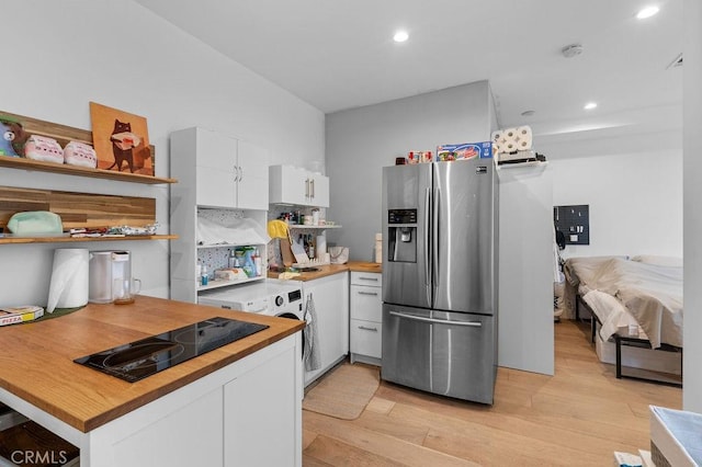 kitchen with white cabinetry, light hardwood / wood-style floors, black electric cooktop, and stainless steel fridge with ice dispenser