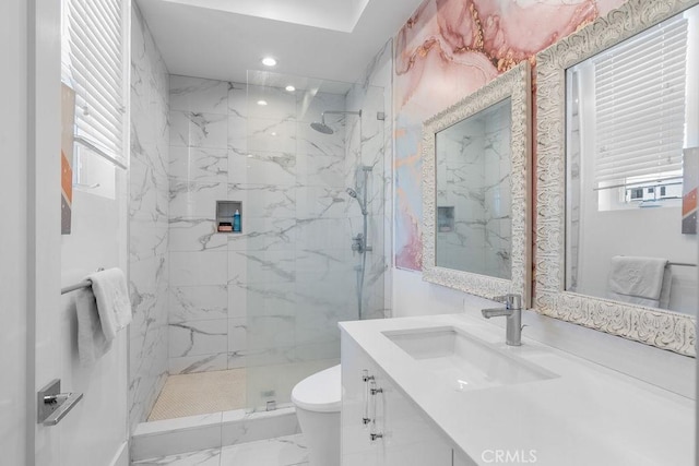 bathroom with vanity, toilet, and tiled shower