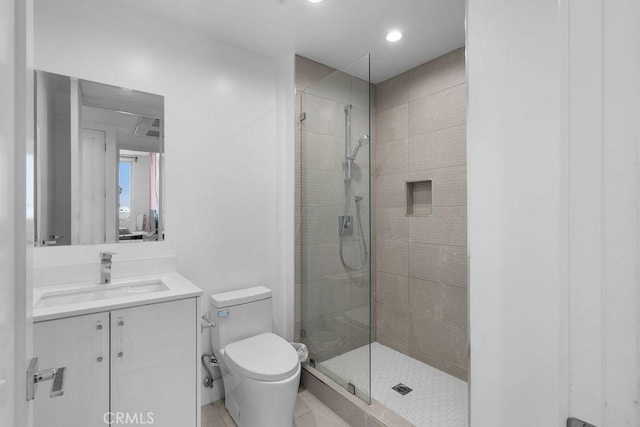 bathroom featuring tile patterned floors, vanity, toilet, and a shower with door