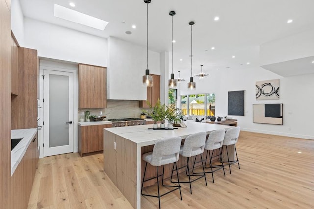 kitchen featuring pendant lighting, a breakfast bar area, light hardwood / wood-style floors, and a spacious island