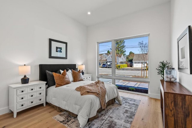 bedroom featuring access to exterior and light hardwood / wood-style flooring