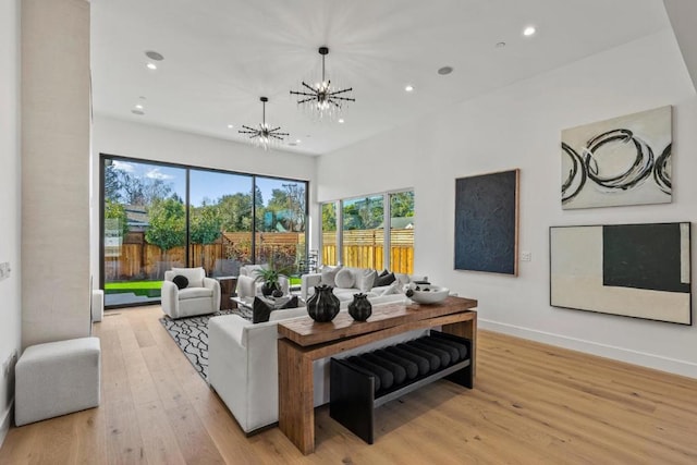 living room featuring light wood-type flooring and a notable chandelier