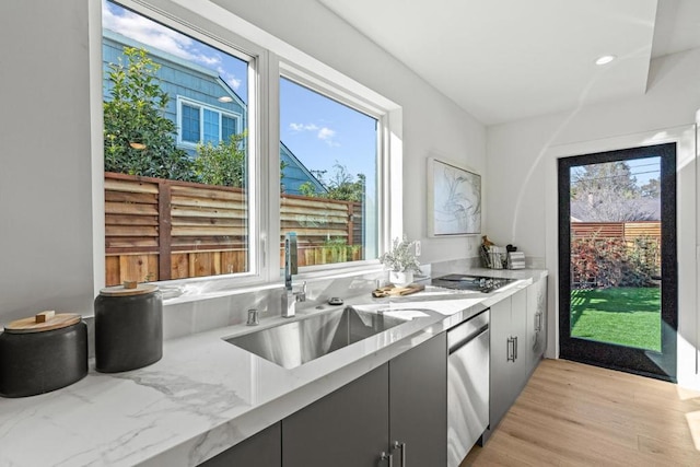 kitchen featuring sink, gray cabinets, stainless steel dishwasher, and plenty of natural light