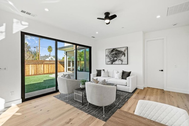 living room with light hardwood / wood-style flooring and ceiling fan