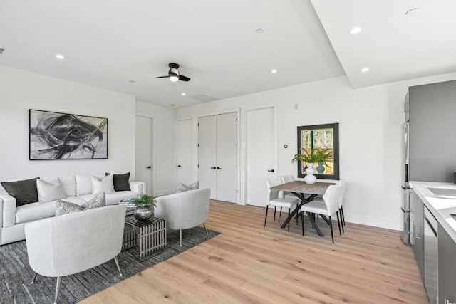 living room with ceiling fan and light wood-type flooring