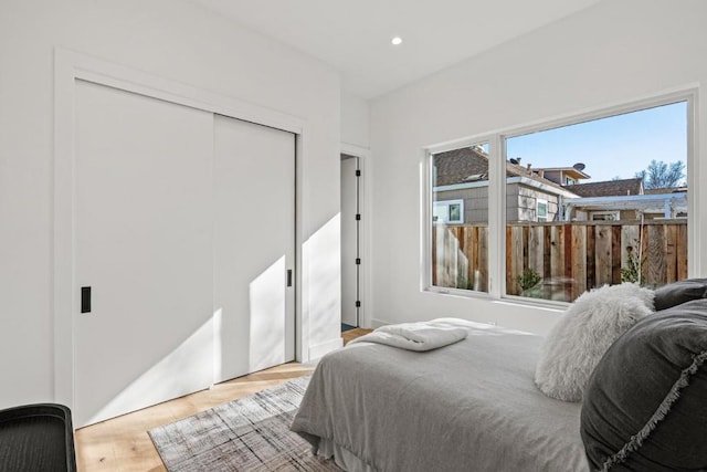 bedroom with light hardwood / wood-style floors and a closet