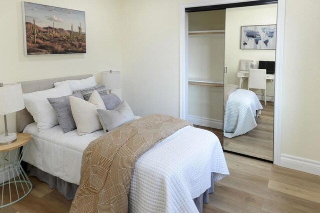 bedroom with light hardwood / wood-style flooring and a closet