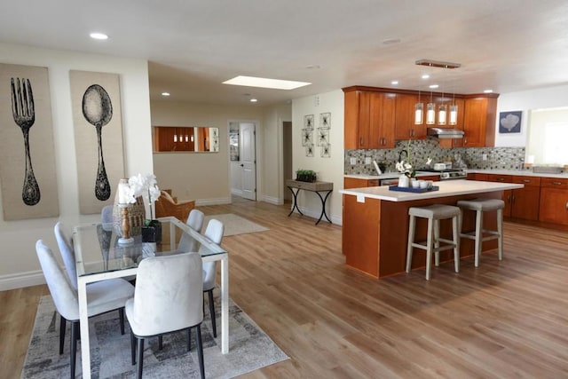 dining area with a skylight and light wood-type flooring