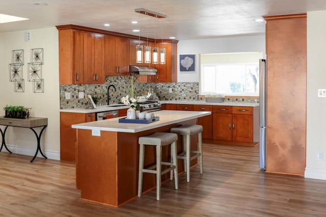 kitchen featuring tasteful backsplash, a kitchen island, pendant lighting, and stainless steel appliances