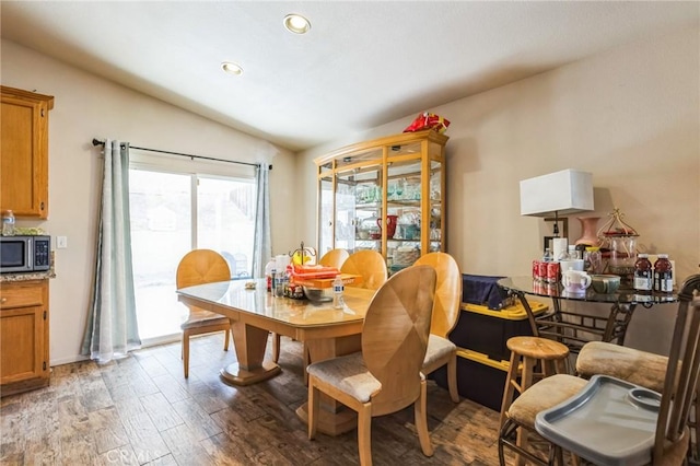 dining area featuring lofted ceiling and light hardwood / wood-style flooring