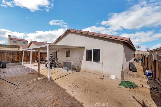 rear view of property featuring central AC unit and a patio area