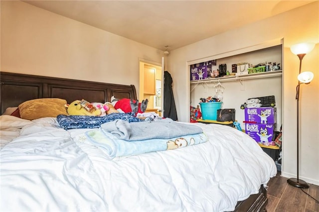 bedroom with dark wood-type flooring and a closet