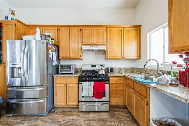 kitchen featuring sink, light stone countertops, and appliances with stainless steel finishes