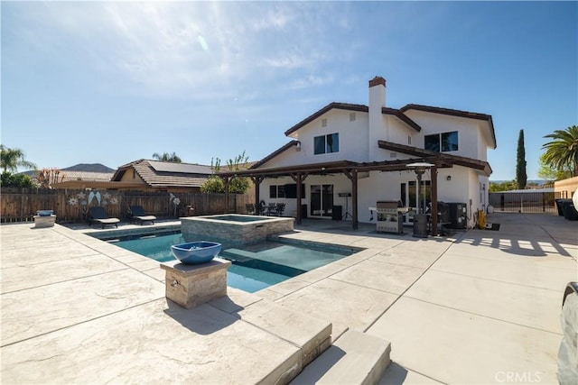 view of swimming pool with a fenced backyard, a pool with connected hot tub, a pergola, and a patio