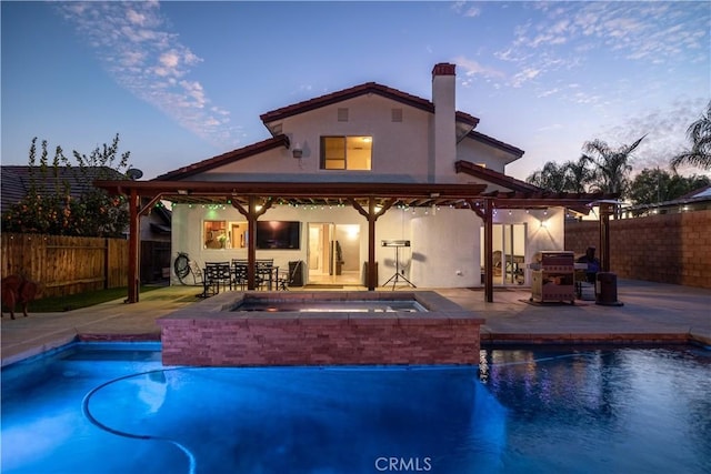 back of house with a fenced in pool, a patio area, a fenced backyard, and stucco siding