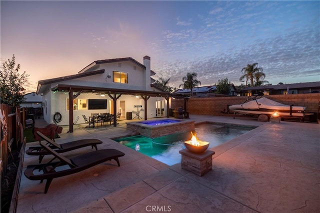 back of property featuring a fenced in pool, a fenced backyard, a chimney, an in ground hot tub, and a patio area