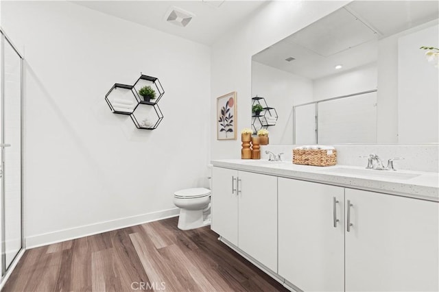 bathroom featuring hardwood / wood-style flooring, vanity, toilet, and a shower with door