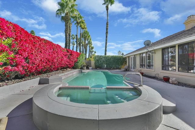 view of pool featuring an in ground hot tub and a patio