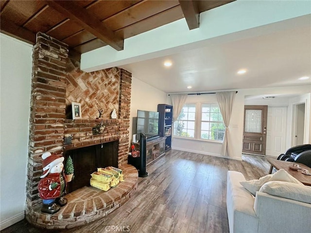 living room featuring wood-type flooring, a fireplace, and vaulted ceiling with beams