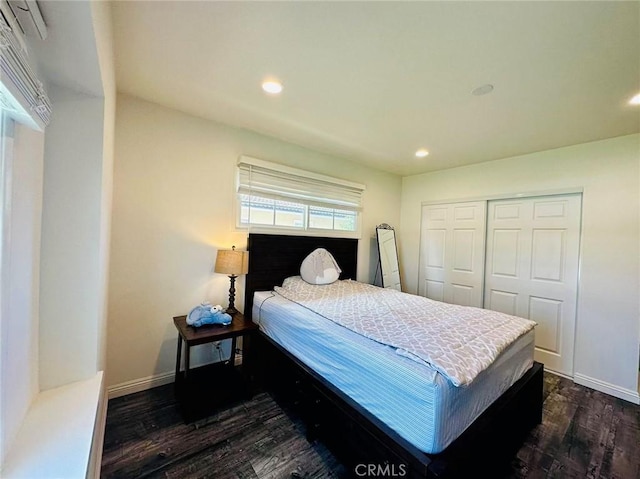 bedroom with dark hardwood / wood-style flooring and a closet