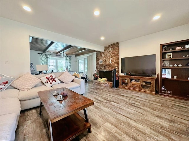 living room featuring hardwood / wood-style flooring, a fireplace, and beamed ceiling