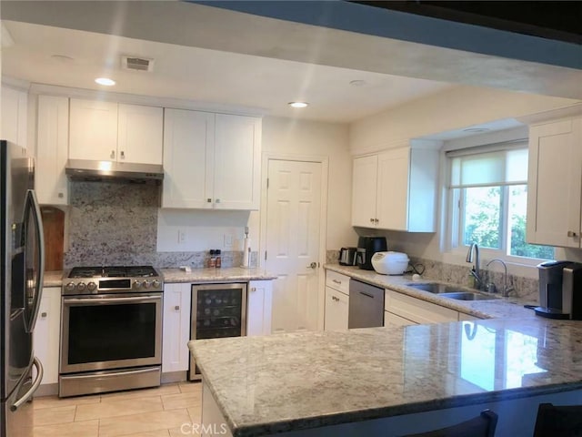 kitchen with white cabinetry, beverage cooler, and appliances with stainless steel finishes