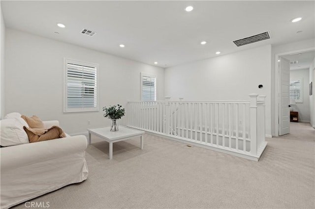 sitting room with recessed lighting, visible vents, and light colored carpet