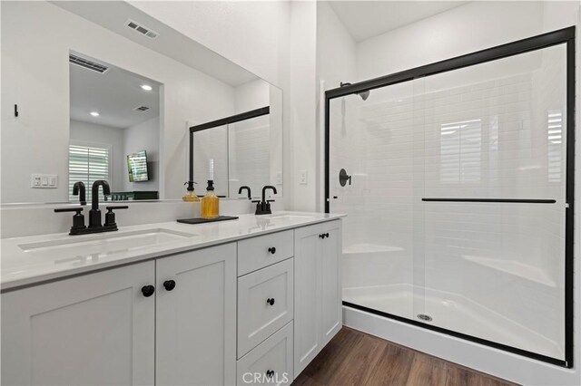 full bathroom with visible vents, a sink, and wood finished floors