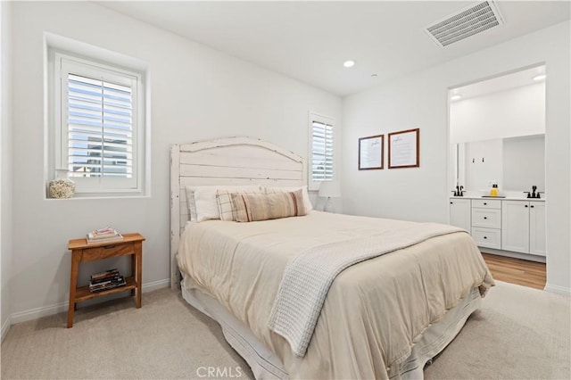 bedroom with baseboards, visible vents, light colored carpet, and recessed lighting