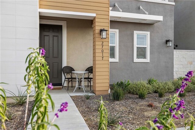 entrance to property with a patio and stucco siding