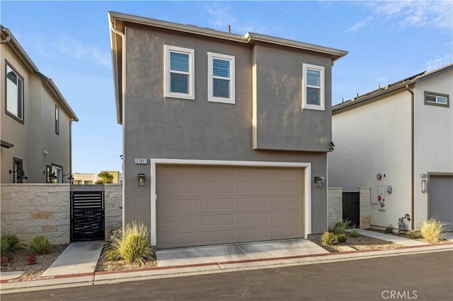 view of front facade featuring a garage, driveway, and stucco siding