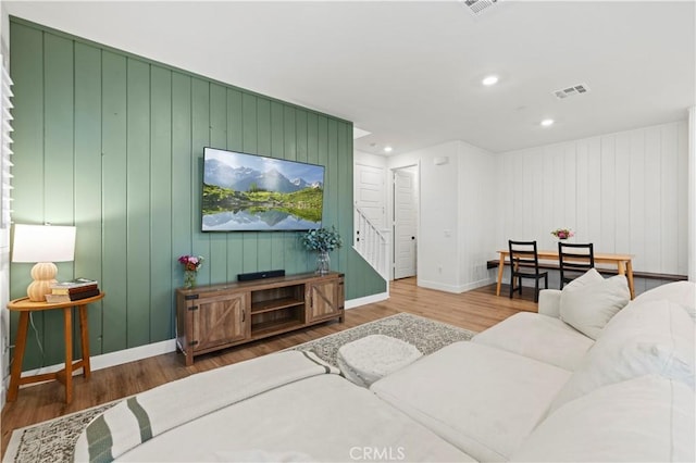 living area with recessed lighting, wood finished floors, visible vents, baseboards, and stairs