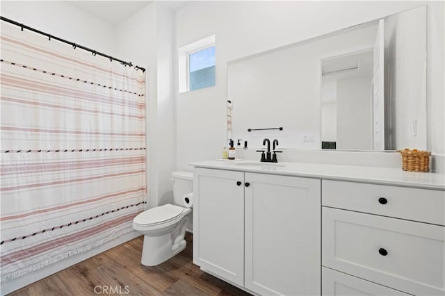 bathroom featuring toilet, wood finished floors, and vanity