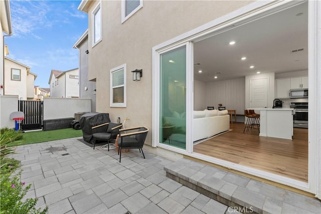 view of patio with fence and visible vents