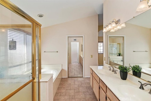 bathroom featuring vaulted ceiling, a bathing tub, and vanity