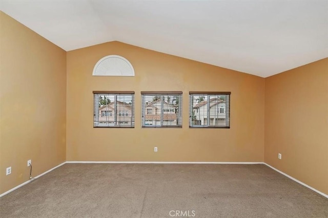 carpeted empty room featuring lofted ceiling