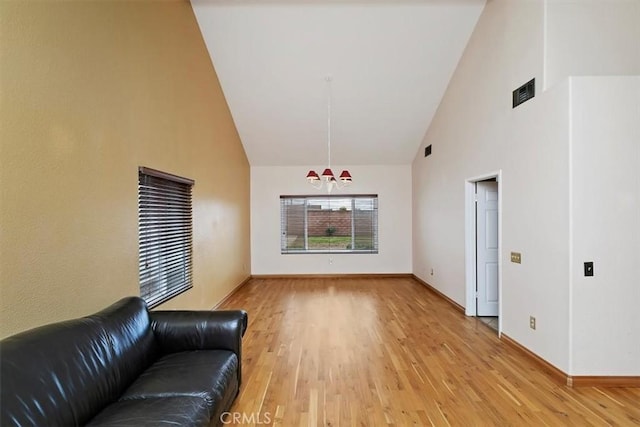 unfurnished living room with wood-type flooring and high vaulted ceiling