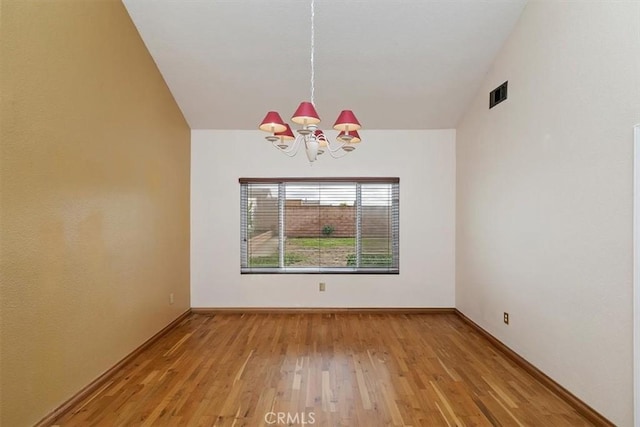 unfurnished dining area with vaulted ceiling, light hardwood / wood-style floors, and a chandelier