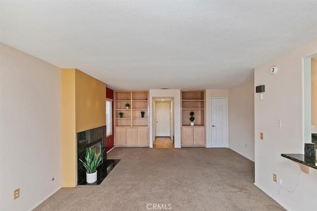 unfurnished living room featuring a high end fireplace and carpet