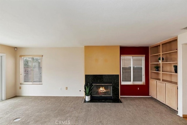 unfurnished living room featuring a fireplace and carpet