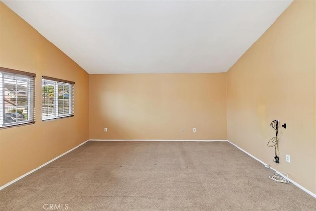 spare room with lofted ceiling and light colored carpet