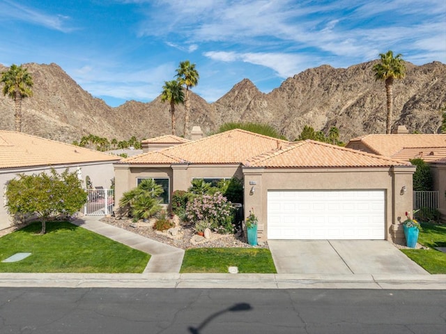 view of front of home featuring a garage, a mountain view, and a front yard