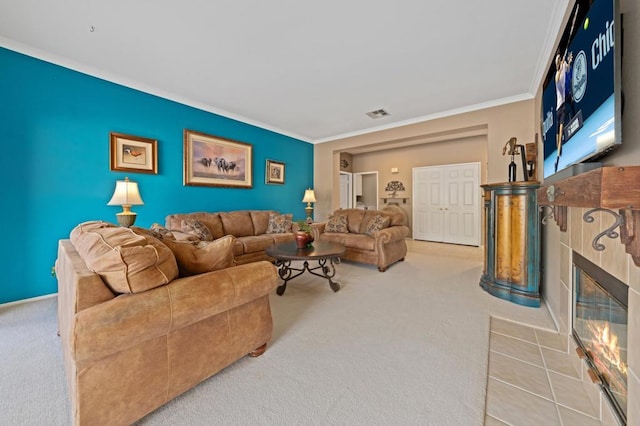 living room with crown molding, light colored carpet, and a tiled fireplace