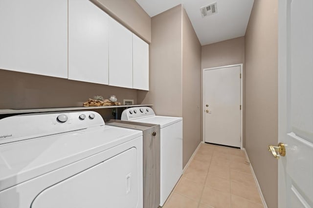 washroom featuring cabinets, washer and clothes dryer, and light tile patterned floors